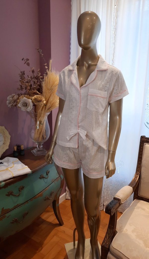 Manequim veste pijama shorts e camisa manga curta na cor branca com debrum rosa